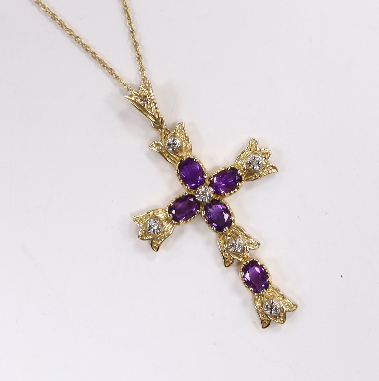 A modern 9k, amethyst and diamond cluster set cross pendant, 51mm, on a 585 yellow metal fine link chain, 45cm, gross weight 7.6 grams.